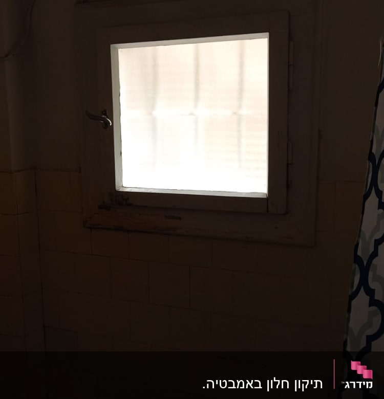 חלון זכוכית עם מסגרת עץ וקיר אריחים